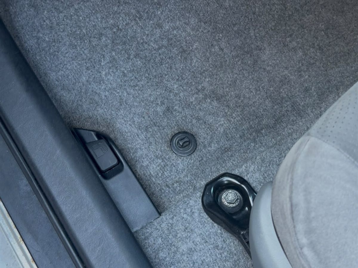 The same car footwell after cleaning, carpet restored to even grey